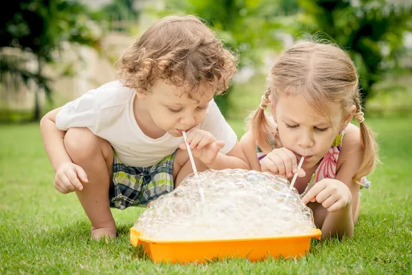 Two happy little kids playing in the garden — Stock Photo, Image