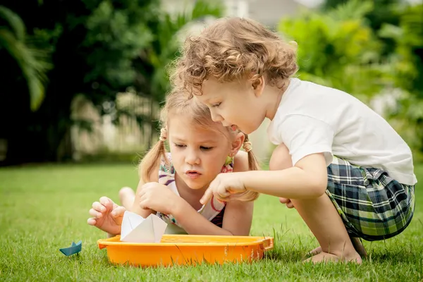 2 つの幸せな小さな子供たちは庭で遊んで — ストック写真