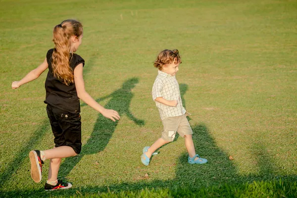 Due bambini felici che giocano nel parco durante il giorno — Foto Stock