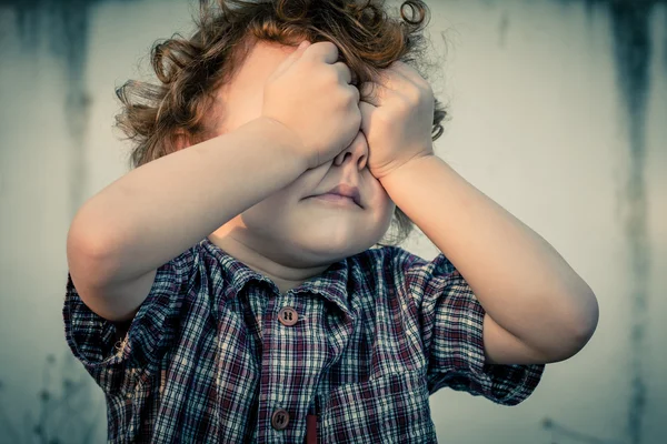 Ein weinender kleiner Junge bedeckt sein Gesicht — Stockfoto