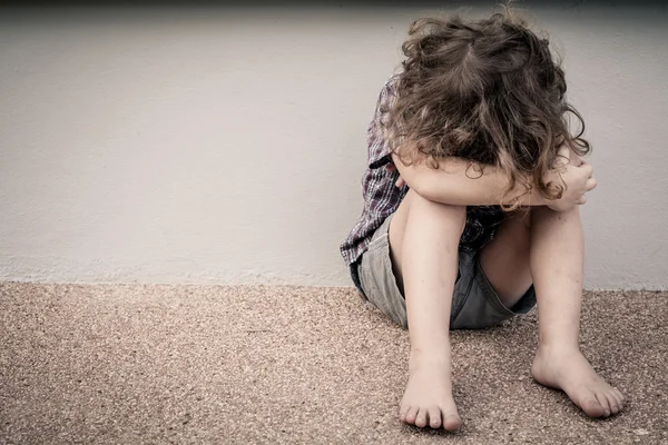 Niño triste sentado en el camino —  Fotos de Stock