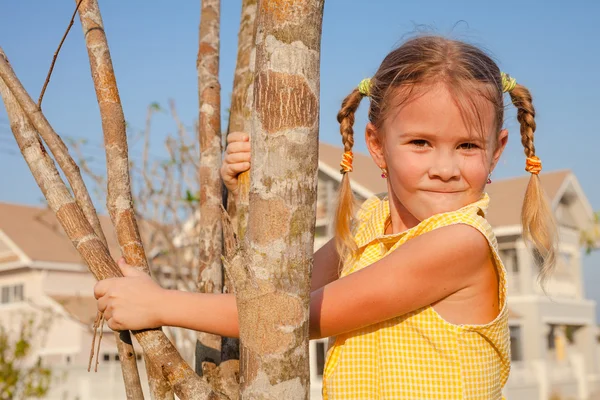 Little girl sitting on the tree — Stock Photo, Image