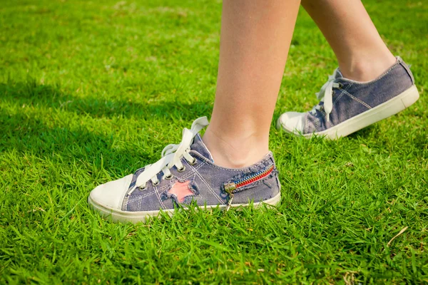 Młodzieży trampki na nogach dziewczyna na trawie latem spokojny słoneczny — Zdjęcie stockowe