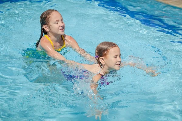 Dvě malé děti hrají v bazénu — Stock fotografie