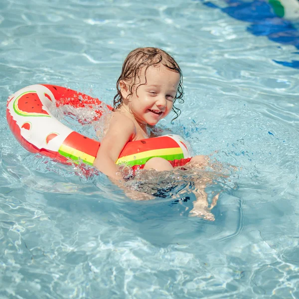 Menino na piscina com anel de borracha — Fotografia de Stock