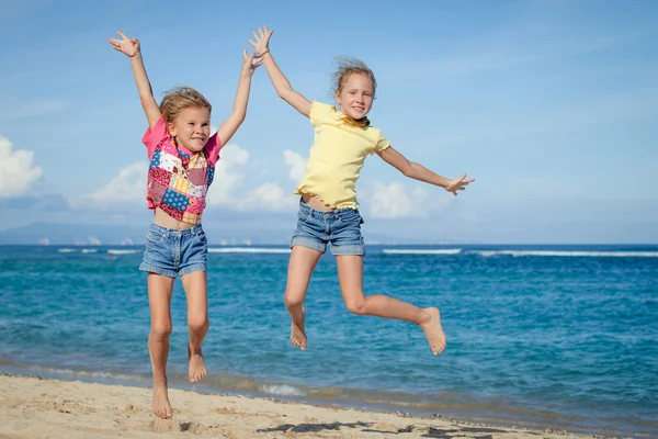 Feliz niñas saltando en la playa — Foto de Stock