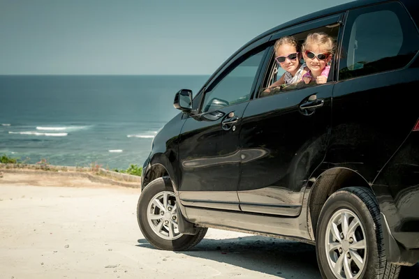 Zwei Schwestern sitzen im Auto am Strand — Stockfoto