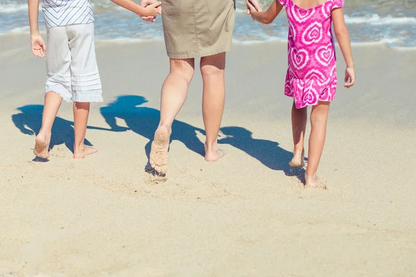 Lycklig familj spelar på stranden under dagarna — Stockfoto