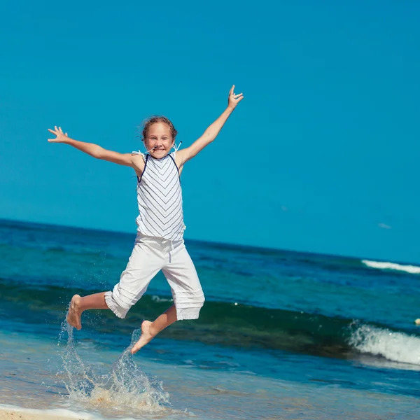 Teen girl  jumping on the beach at blue sea shore in summer vaca — Stock Photo, Image