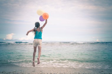 Kız sahilde su mavi deniz sahilinde atlama balonları