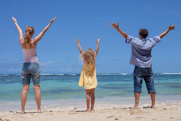 Glad familj stående på stranden under dagarna — Stockfoto