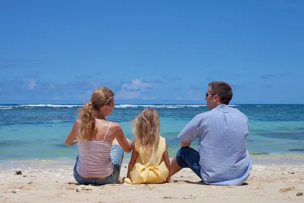 Lycklig familj sitter på stranden under dagarnašťastná rodina sedí na pláži v denní době — Stockfoto