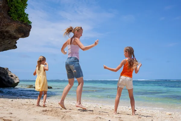 Gelukkige familie springen op het strand in de dagtijd — Stockfoto