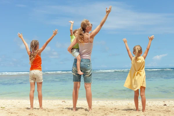 Familia feliz jugando en la playa durante el día — Foto de Stock