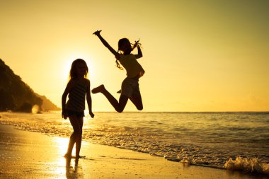 mutlu çocuklar gündoğumu zaman kumsalda oynarken