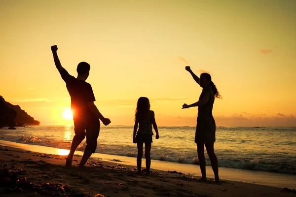 Lycklig familj spela på stranden på dagarna — Stockfoto