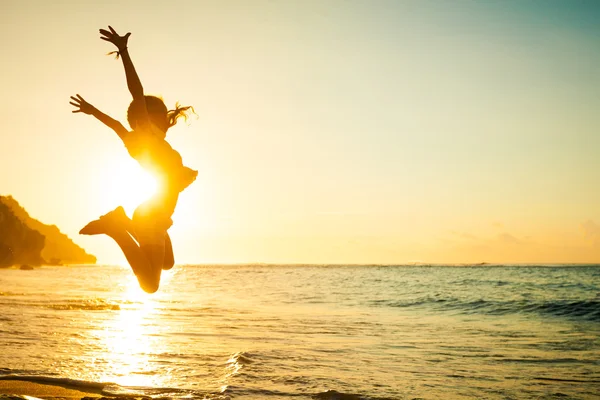 Menina adolescente pulando na praia na hora do dia — Fotografia de Stock