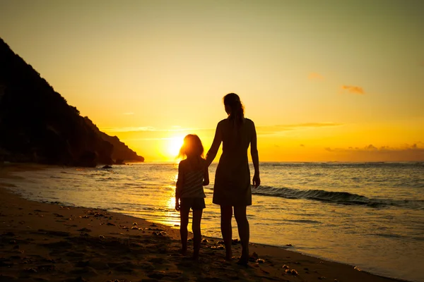 Anne ve kızı kumsalda güneş doğarken oynama — Stok fotoğraf