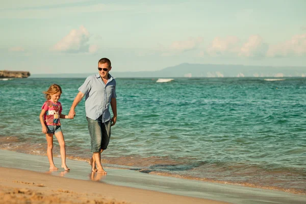 Father and daughter walking on the beach at the day time — Stock Photo, Image