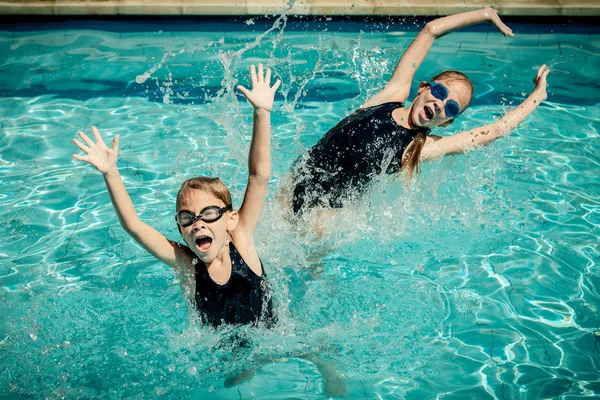 在游泳池里玩的两个快乐的小女孩 — 图库照片