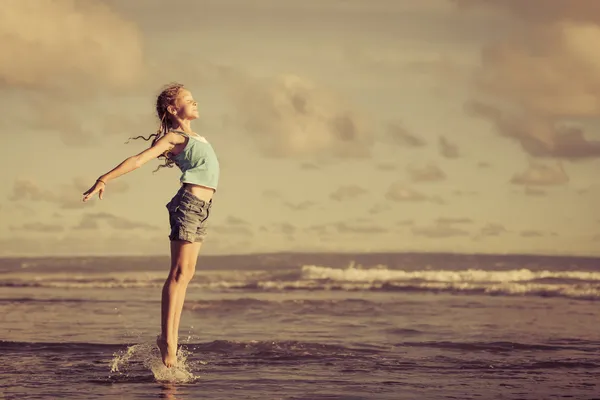 Teen girl  jumping on the beach at blue sea shore in summer vaca — Stock Photo, Image