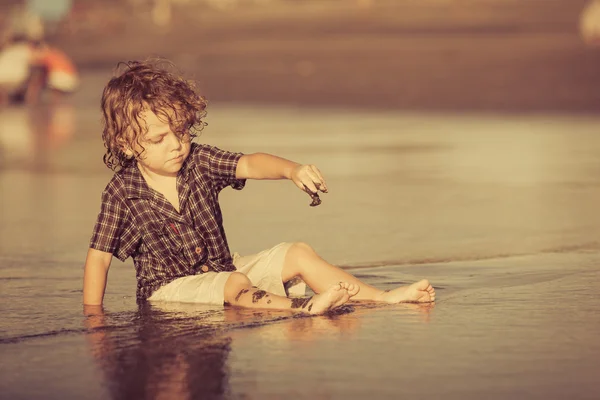 Kleiner Junge spielt tagsüber am Strand — Stockfoto