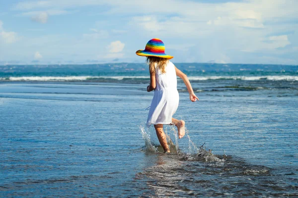 Ragazzina felice che cammina sulla spiaggia durante il giorno — Foto Stock