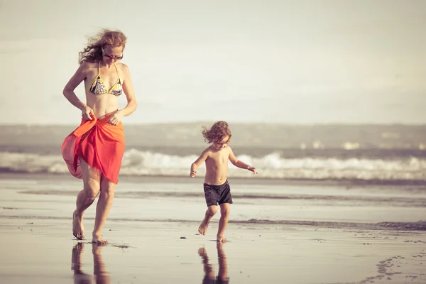 Mor och son spelar på stranden under dagarna — Stockfoto
