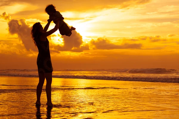 Mor och son leker på stranden — Stockfoto