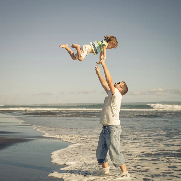 Pai e filho brincando na praia no dia — Fotografia de Stock