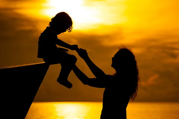 Madre e hijo jugando en la playa al amanecer — Foto de Stock