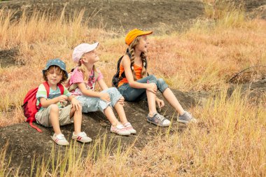 küçük çocuğa m patika üzerinde oturan sırt çantası