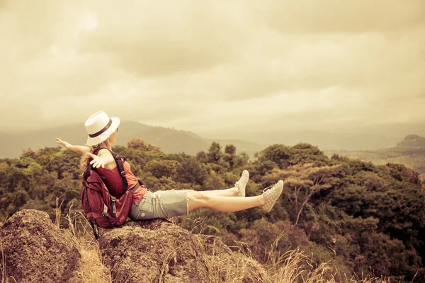 Turista con zaino rilassante sulla roccia e godendo ammirando il — Foto Stock