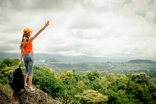 Adolescente con una mochila de pie en una cima de la montaña — Foto de Stock