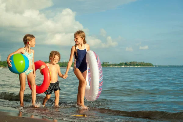 Glückliche Kinder, die tagsüber am Strand spielen — Stockfoto