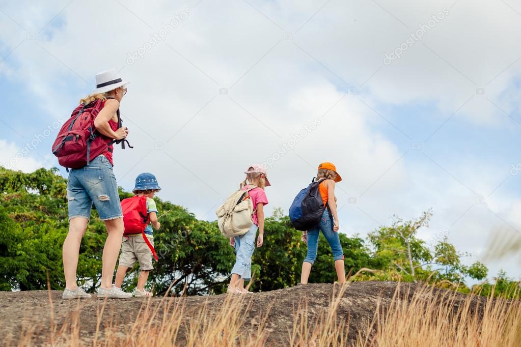 three little kids and mother in the mountains