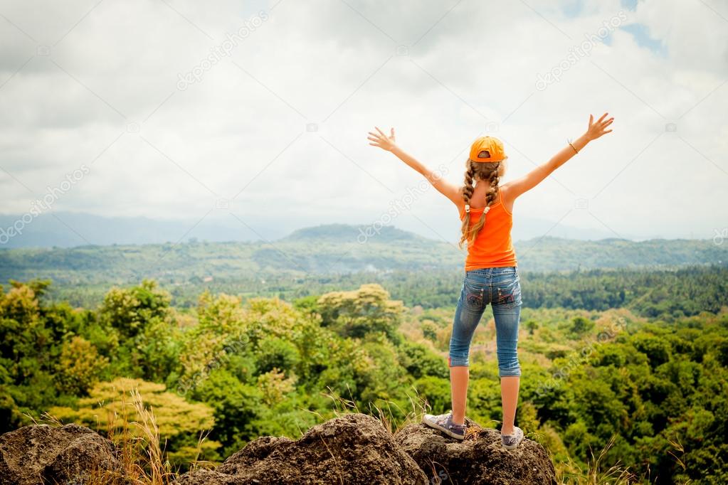 teenager  standing on a mountain top