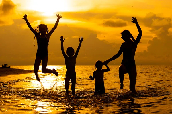 Feliz família brincando na praia na madrugada timeh — Fotografia de Stock