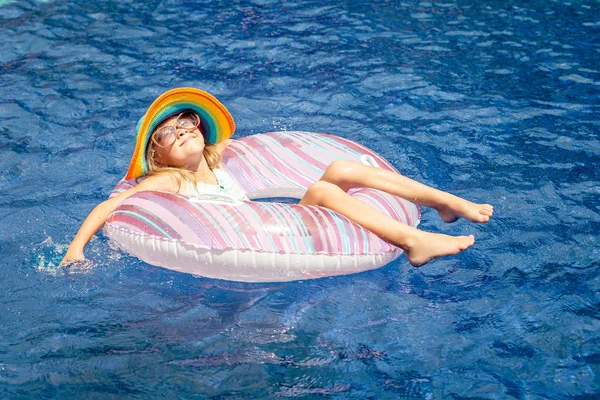 Lilla flickan liggande på uppblåsbara gummi cirkeln i simma — Stockfoto