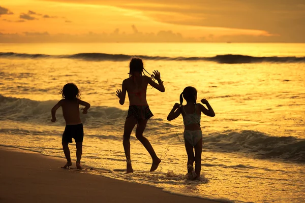 Şafak zaman kumsalda oynarken mutlu çocuk — Stok fotoğraf