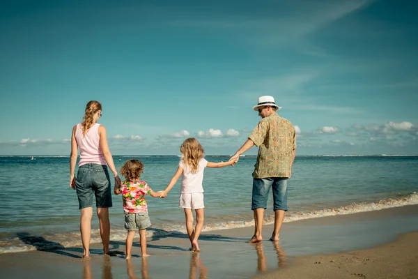 Lycklig familj promenader på stranden på dagarna — Stockfoto