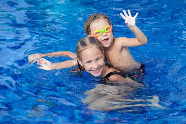 Bror och syster leker i poolen Stockfoto