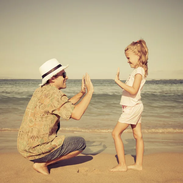 Vader en dochter spelen op het strand op het moment van de dag — Stockfoto