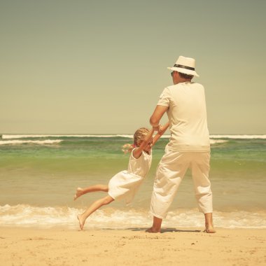 Baba ve kızı kumsalda gün anda oynamak