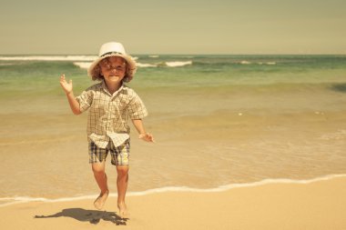 küçük çocuk kumsalda gün zamanda atlama