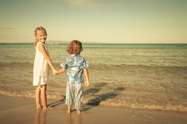 Niños felices jugando en la playa durante el día —  Fotos de Stock