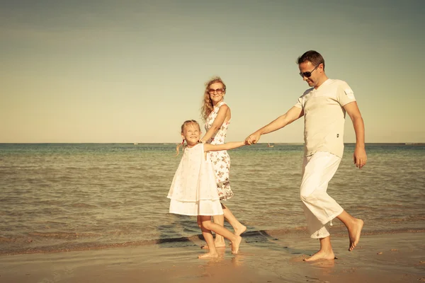 Gelukkige familie wandelen op het strand op het moment van de dag — Stockfoto