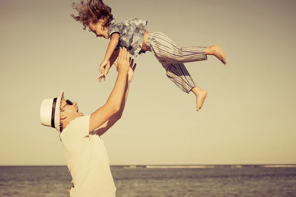 Padre e figlio che giocano sulla spiaggia durante il giorno — Foto Stock