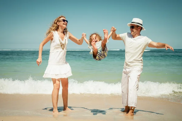 Famiglia felice che gioca sulla spiaggia durante il giorno — Foto Stock