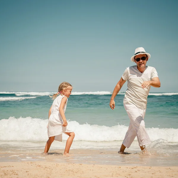 Отец и дочь играют на пляже в дневное время — стоковое фото